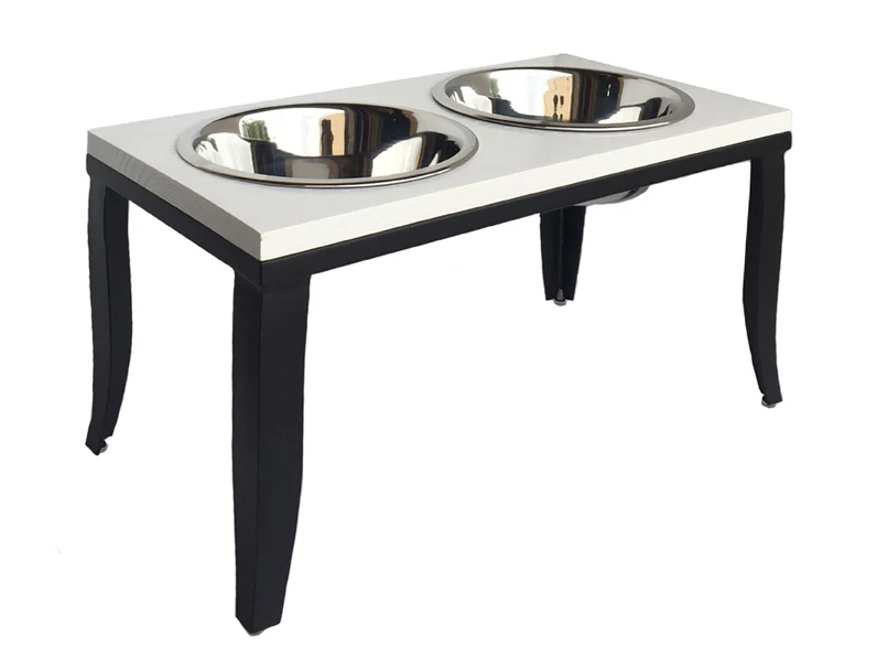 Raised pet feeder with two stainless steel bowls on a white top and black curved legs (for dogs or cats).
